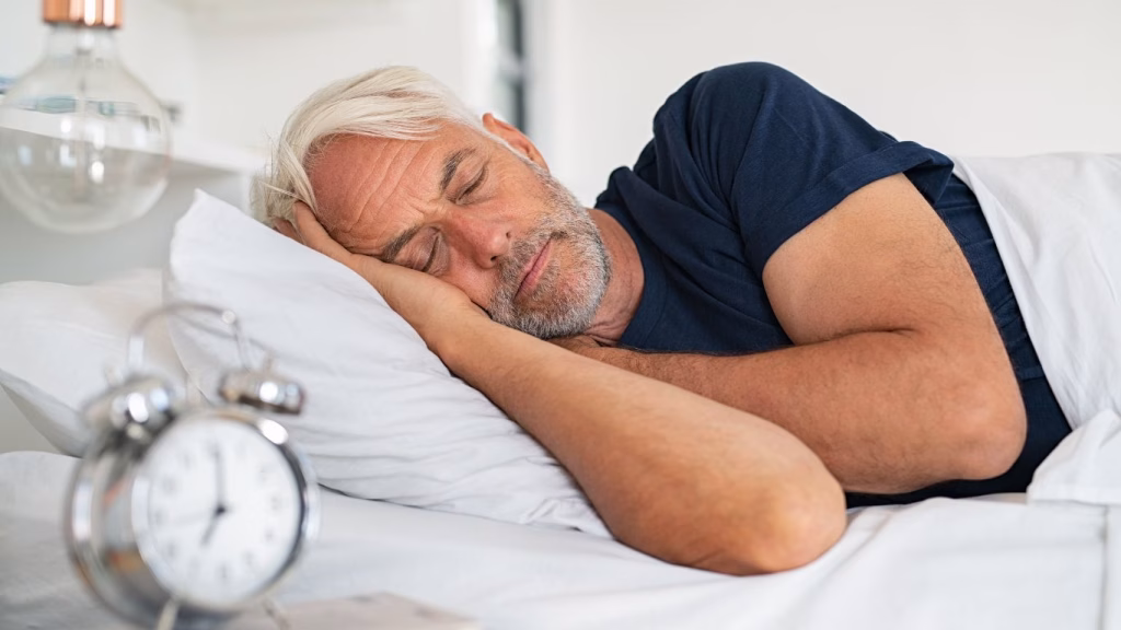 A middle aged man in bed, sleeping peacefully