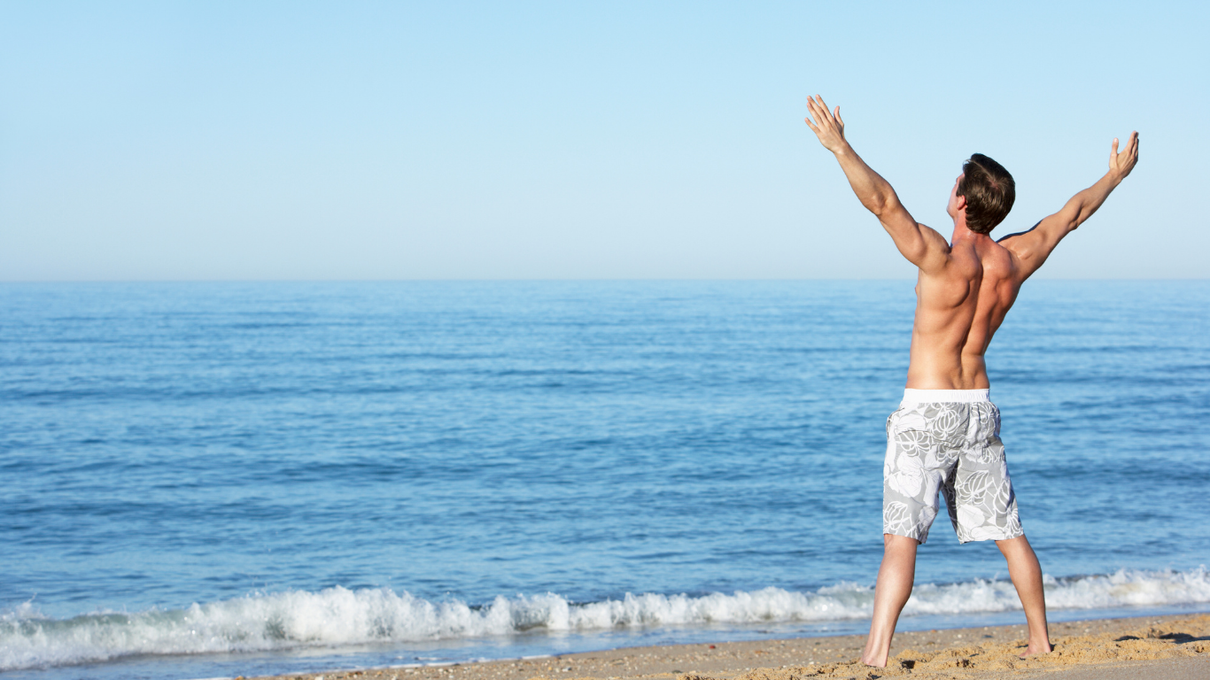 image of man at the beach stretching
