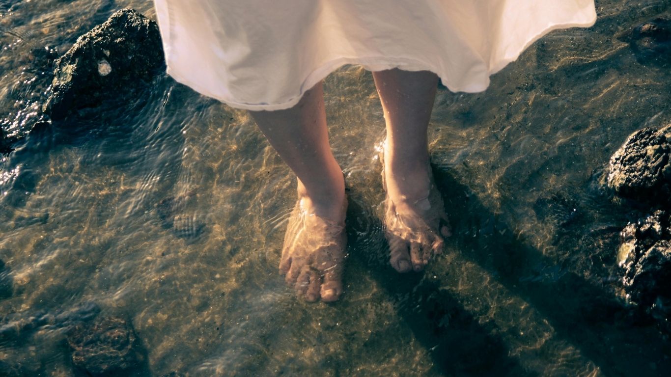 An image of a woman's feet in water