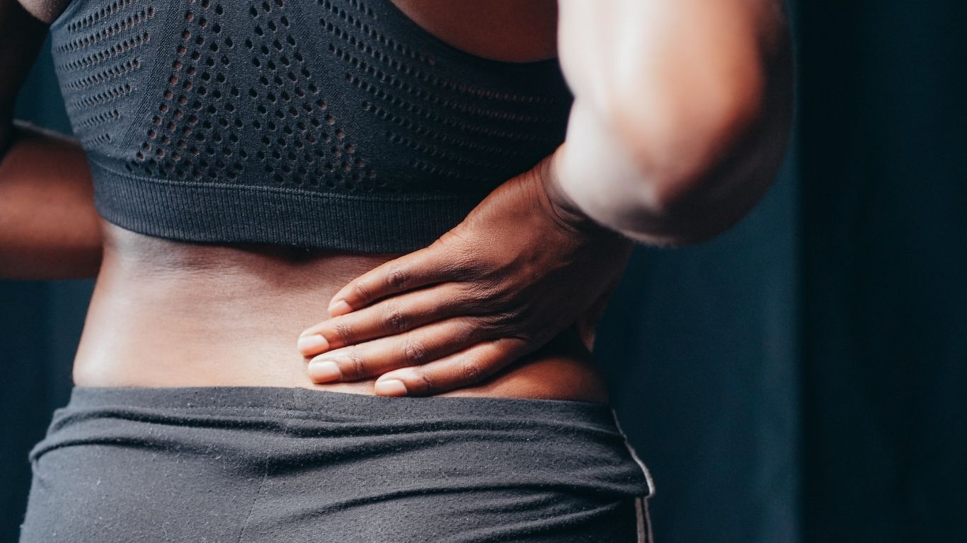 woman holding her back in pain