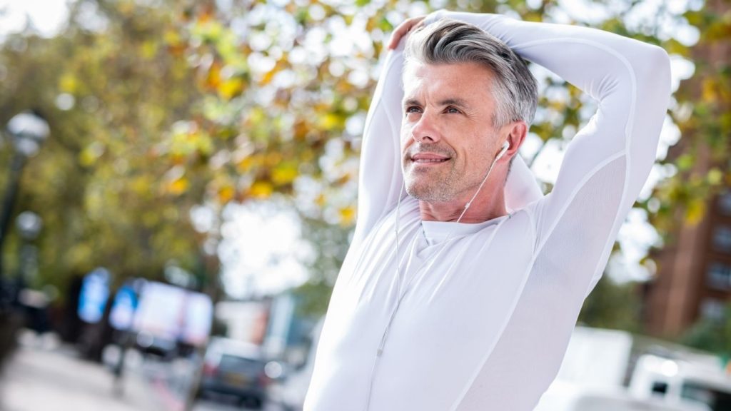 A middle-aged man stretching and looking refreshed