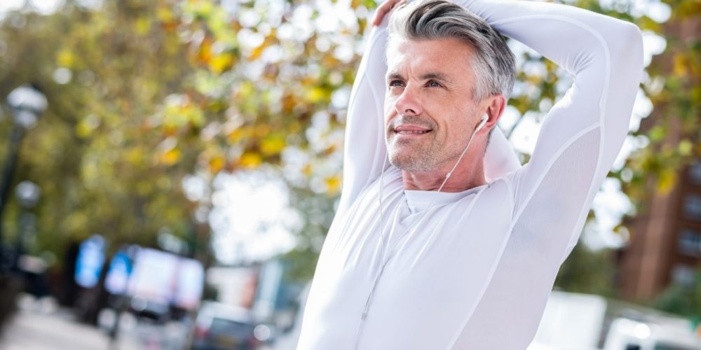 A middle-aged man stretching and looking refreshed