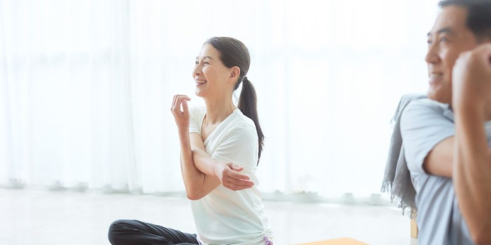 Man and woman sitting an stretching