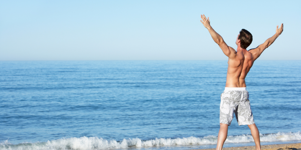 image of man at the beach stretching