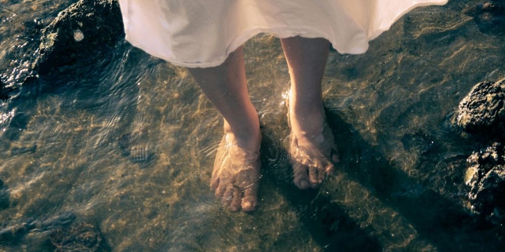 An image of a woman's feet in water