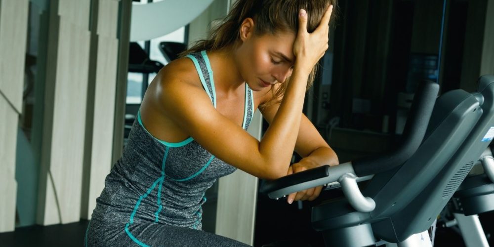 woman at gym with her head in her hands