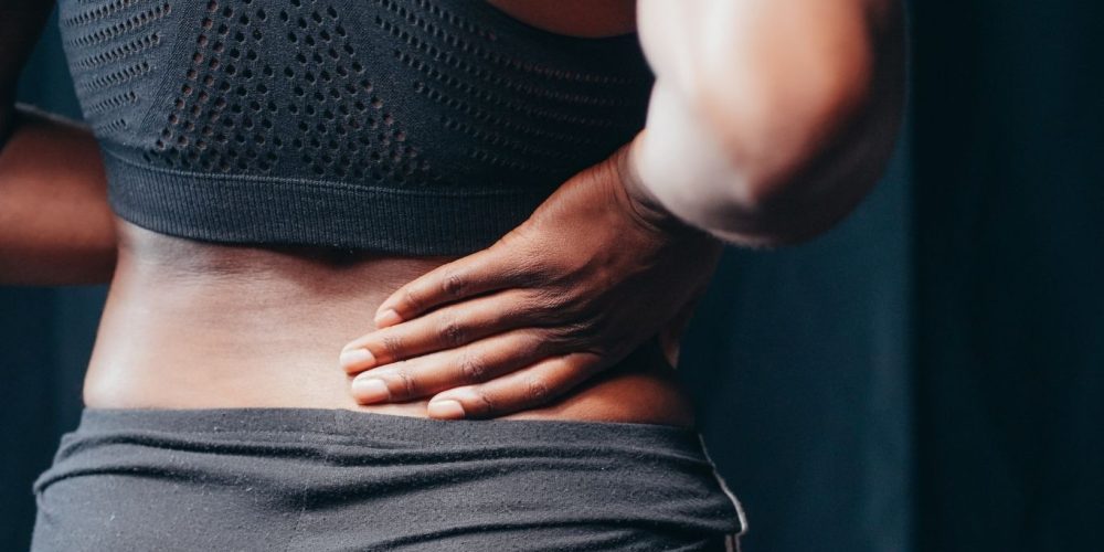 woman holding her back in pain